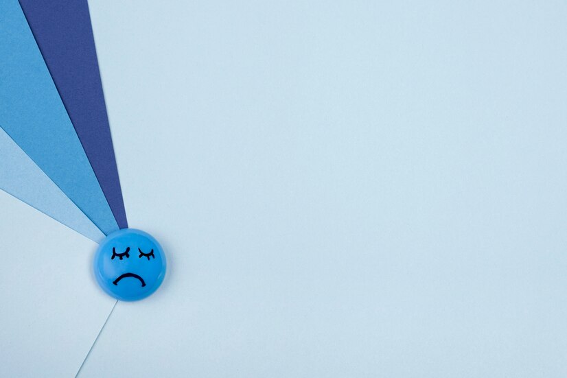 A blue image with a different shades of blue pointing to a frowning face. This is to symbolize grieving and relationships